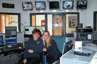 Two dispatchers standing in Public Communications office